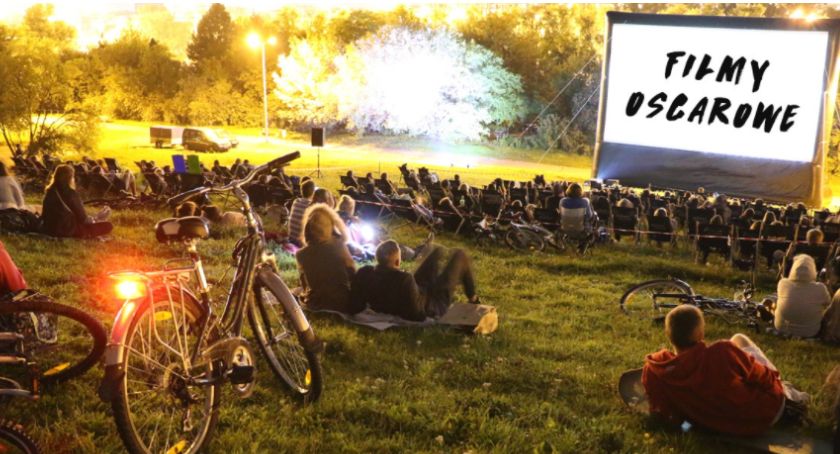 Kino plenerowe. Ludzie na trawie. 